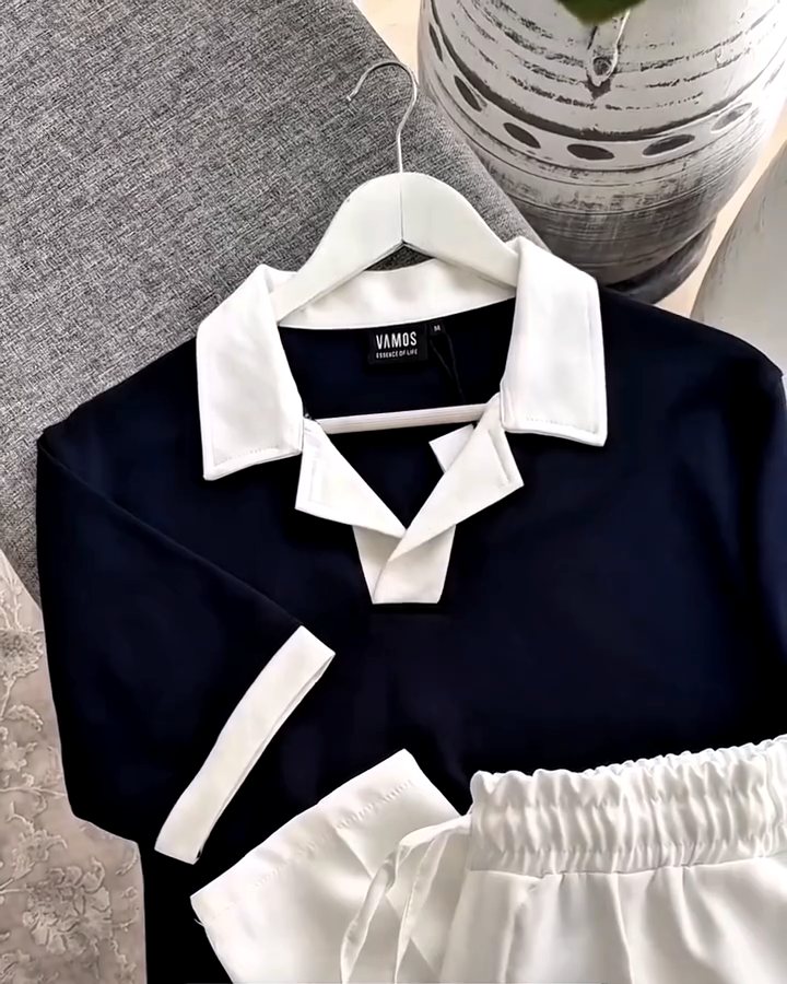 Navy knit polo with cream collar on a hanger